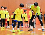 子どもたちにステップワークを指導する長谷川選手（右）＝２７日、倉吉体育文化会館