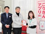 寄付を受け取る松井委員長（右）