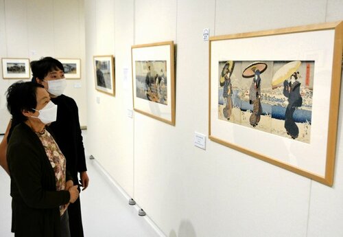 大判３枚続きの美人画に見入る来場者＝１３日、米子市美術館