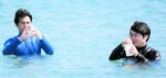 海水を採水する但馬県民局の職員＝１６日、豊岡市竹野町の竹野浜海水浴場