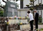 　紫雲丸の沈没事故から７０年となり、犠牲となった生徒の名前が刻まれた高知市立南海中の石碑に手を合わせる参列者＝１１日午前、高知市