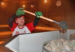 石に番茶をかける熱風亭助六さん＝７日、米子市角盤町１丁目