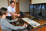 専用の機器を使い、林業の現場を体感する学生＝１３日、鳥取市湖山町西２丁目の鳥取県森林組合連合会