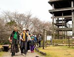 高床式建物などを巡りながら園内を歩く参加者