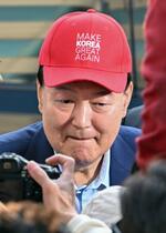 　１１日、ソウルの大統領公邸近くで「メーク・コリア・グレート・アゲイン」と書かれた帽子をかぶり支持者にあいさつする尹錫悦氏（共同）