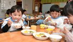 炊きたての温かいご飯をおいしそうにほおばる園児＝２日、鳥取市吉方温泉１丁目のわかばこども園