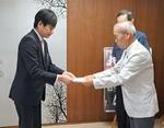 　新潟県上越市役所で中川幹太市長（左）に署名を手渡すＮＰＯ法人「高田瞽女の文化を保存・発信する会」の濁川清夏理事長＝２０２４年７月、同法人提供