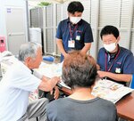 買い物客（手前）に個別配達などの利用方法を紹介する県生協のスタッフ＝２日、倉吉市関金町関金宿のＡコープせきがね店