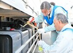 トラックから軽油を抜き取る県職員＝１５日、琴浦町別所の道の駅「琴の浦」