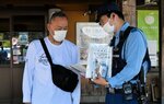 買い物客らに啓発チラシなどを手渡す関係者（右）＝１日、鳥取市河原町高福の道の駅清流茶屋かわはら