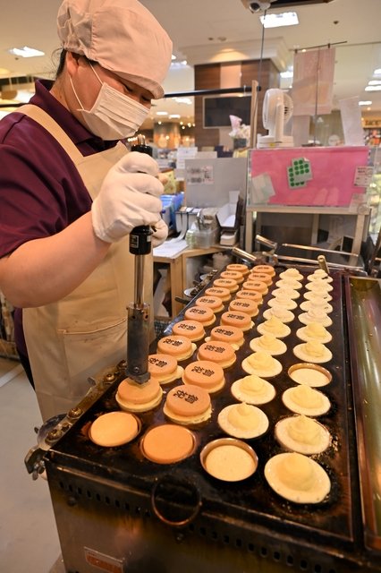 専用の金型で「御祝」の字を焼き付ける従業員＝２３日、鳥取市今町２丁目の丸由百貨店