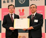 協定書に署名を交わした松本支社長（左）と深沢市長＝３１日、鳥取市役所