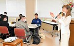 坪内代表（右）から笑顔で接することの大切さを学ぶ新入社員たち＝９日、豊岡市大磯町の豊岡商工会議所