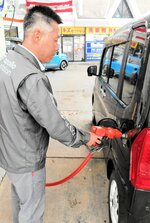 先行値下げしたガソリンを軽乗用車に給油するスタッフ＝２２日、鳥取市雲山のハートランド雲山