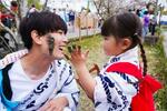 　「どろんこ祭り」で父親の顔に泥を塗る女の子＝５日午後、高知市