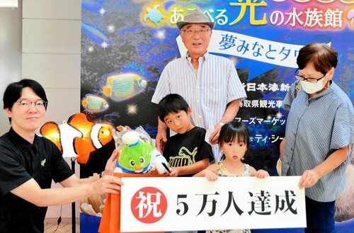 掃部館長（左）から記念品を贈られた石原憲吾さん（中央前）ら＝２０日、境港市の夢みなとタワー