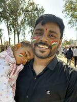 　インド国旗を顔にペイントした親子＝２０２５年３月、インド・アタリ（共同）