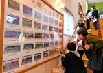 歴代の卒園記念写真を眺める卒園生ら