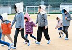 大津波警報が出たとの想定で園児の手を引いて避難する児童たち＝７日、香美町香住区大野の長井小