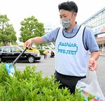 植え込みに捨てられたごみを拾う参加者＝３１日、ＪＲ鳥取駅前