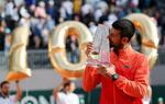 　ジュネーブ・オープンの男子シングルス決勝で優勝して通算１００勝を達成し、トロフィーにキスするジョコビッチ＝２４日（ロイター＝共同）