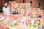 縁起物の熊手を手に参拝を呼びかける中島宮司＝３０日、新温泉町浜坂の宇都野神社