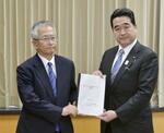 　南海トラフ巨大地震の新たな被害想定に関する報告書を、坂井防災相（右）に手渡す福和伸夫名古屋大名誉教授＝３月３１日、東京・霞が関