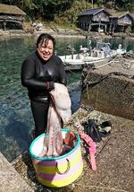 　海女漁で捕ったタコを手にする大西幸子さん＝京都府伊根町（本人提供）