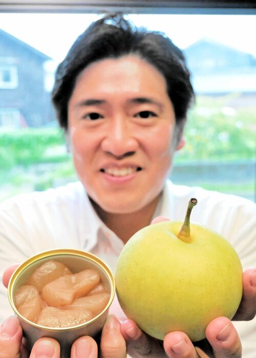 廃棄される梨を有効活用しようと開発した缶詰「香住梨のたいたん」と吉川さん＝香美町香住区下浜