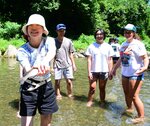 米国人学生らと一緒に、ニジマスのつかみ捕りを体験する高校生＝２２日、倉吉市関金町小泉の清流遊ＹＯＵ村