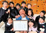 大賞受賞を喜ぶ米田園長（中央）と園児たち＝１５日、倉吉市広栄町の森のようちえんキンダーガーデン