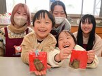 大学生（後列）と一緒に作った銅鐸型のチョコを手にする子どもたち
