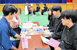 真剣な表情で企業担当者（左）の説明を聞く生徒＝２１日、香美町村岡区の村岡高