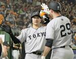 　４回、本塁打を放ち、グリフィン（右）に迎えられる巨人・泉口＝東京ドーム