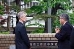 　横田めぐみさんが通っていた新潟市立寄居中の前で、担当者から説明を受ける在日米大使館のジェローム・ライアン１等書記官（左）＝１２日午前、新潟市中央区
