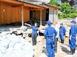 増水した三徳川の濁流で損壊した露天風呂の状況などを自民党国会議員らに説明する大橋社長（左）＝１９日、三朝町三朝
