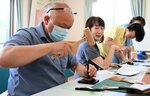 木づちと専用の工具で革に縫い穴を開ける参加者