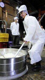昔ながらの「酛すり」を体験する吉川さん＝５日、鳥取市立川町２丁目の中川酒造