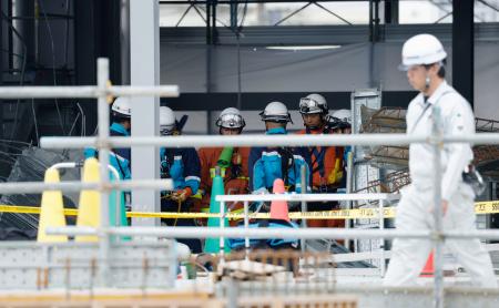 　建築資材が落下した工事現場で、救出活動をする消防隊員ら＝２８日午後、川崎市川崎区