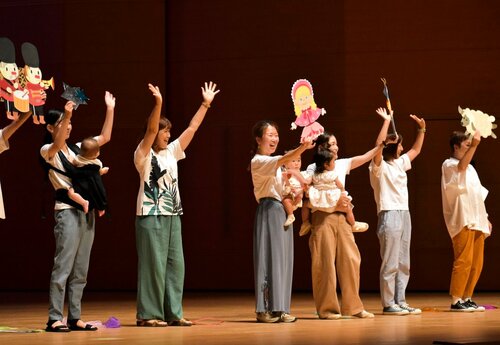 振り付けを交えながら童謡を披露する出演者