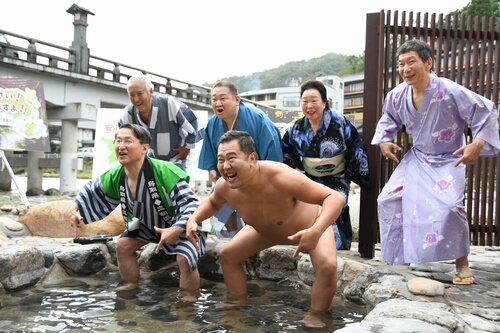 おなじみのポーズで元気な三朝温泉をアピールする、とにかく明るい安村さん（前列右）と平井知事（同左）ら＝８日、三朝町三朝の河原風呂