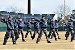指先まで意識を集中して発声やジェスチャーの練習をする参加者ら＝どらドラパーク米子市民球場