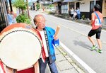 【太鼓で鼓舞】　ランナーを鼓舞しようと太鼓をたたいて応援する住民も。ばちを握る手に力がこもる