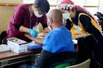 　群馬県太田市で開かれた無料の健康診断で採血を受ける仮放免者（手前）＝６月