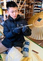 小刀で傘の骨となる竹を丁寧に整える板井さん