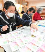 年賀状に１枚１枚色を塗っていく部員と民生委員ら＝１日、鳥取市東町３丁目の鳥取市立北中