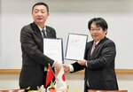 基本合意を締結して握手を交わす丁ＣＥＯ（左）と広江理事長＝５日、米子市両三柳