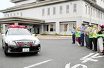 関係者に見送られて出発するパトカー＝２１日、倉吉署