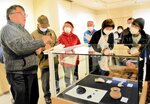 下高館長（左）から展示品の解説を受ける市民ら