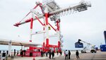 ガントリークレーン２号機による荷役作業のデモンストレーションを見学する式典出席者ら＝１１日、鳥取県境港市昭和町